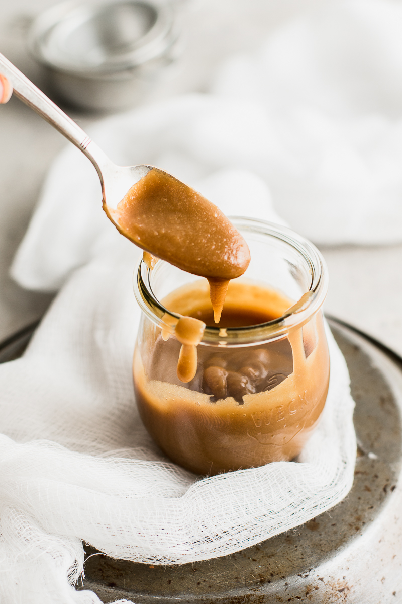 vegan caramel sauce dripping from a spoon