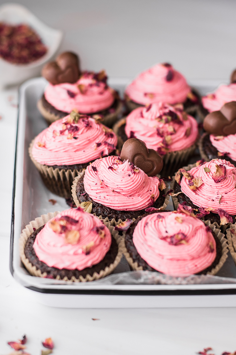 strawberry frosting topped chocolate cupcakes with rose petals