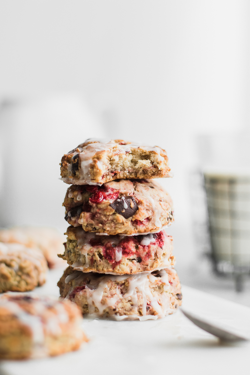 Roasted strawberry chocolate oat scones on white background drizzled with glaze.