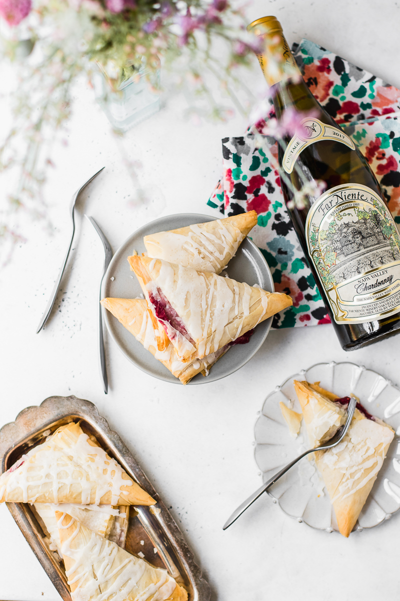 raspberry turnovers on plates and bottle of chardonnay