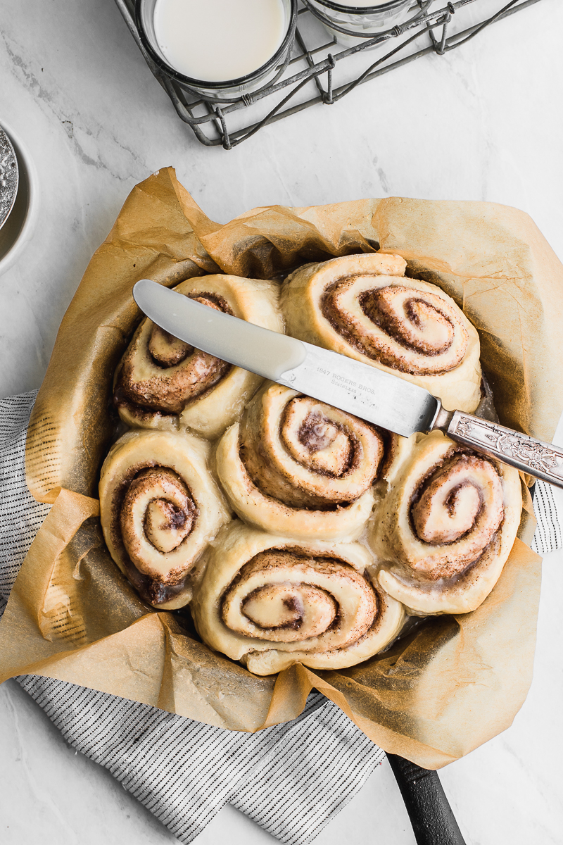 cinnamon rolls in skillet with knife