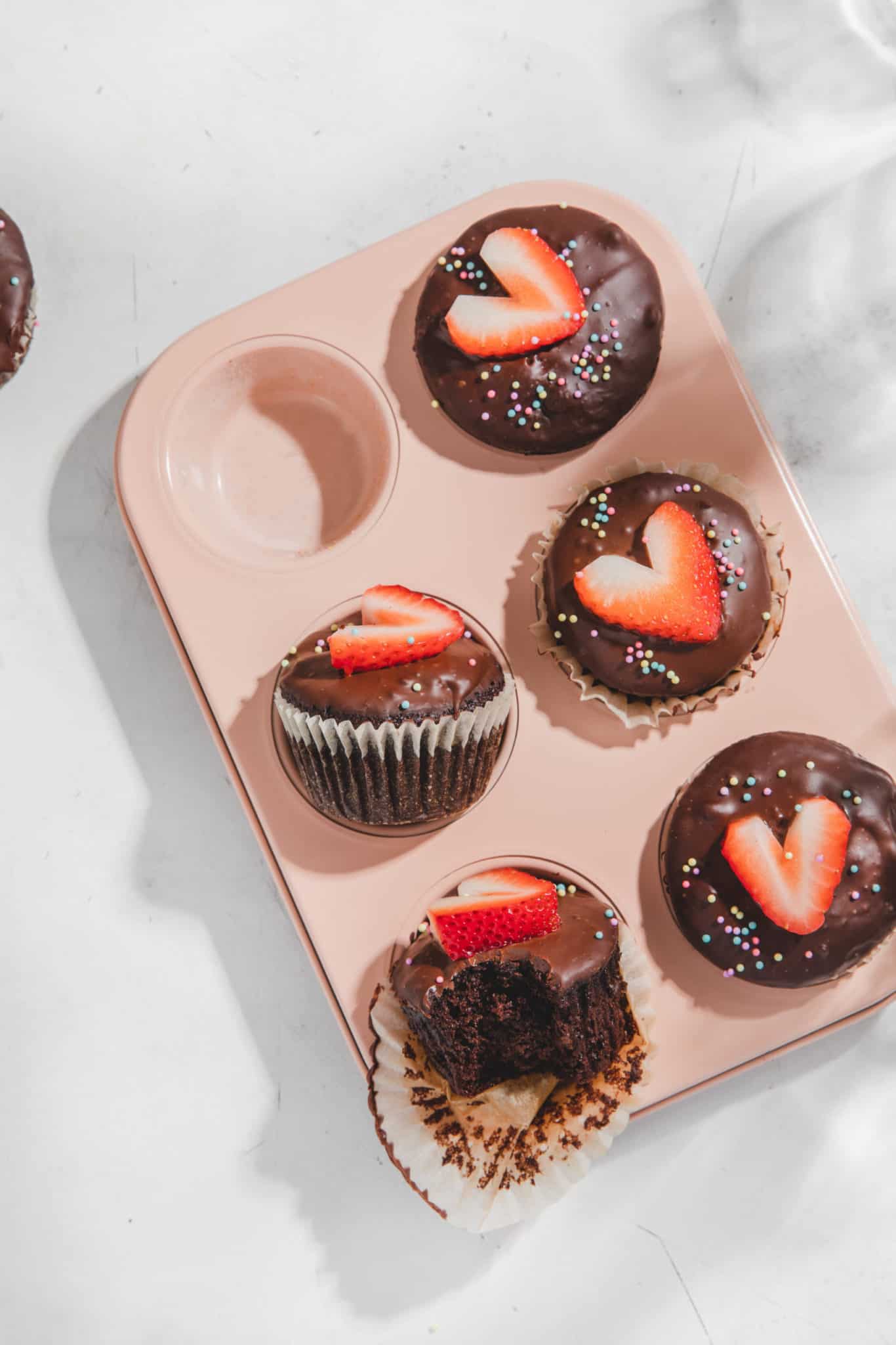 low carb Valentine's Day treats in a pink pan with strawberries and chocolate ganache