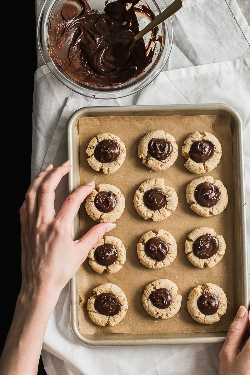 hands grabbing paleo shortbread cookies filled with chocolate