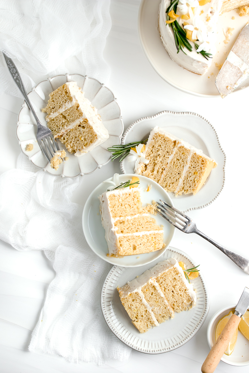 Flat lay of lemon olive oil cake slices and forks on white background.