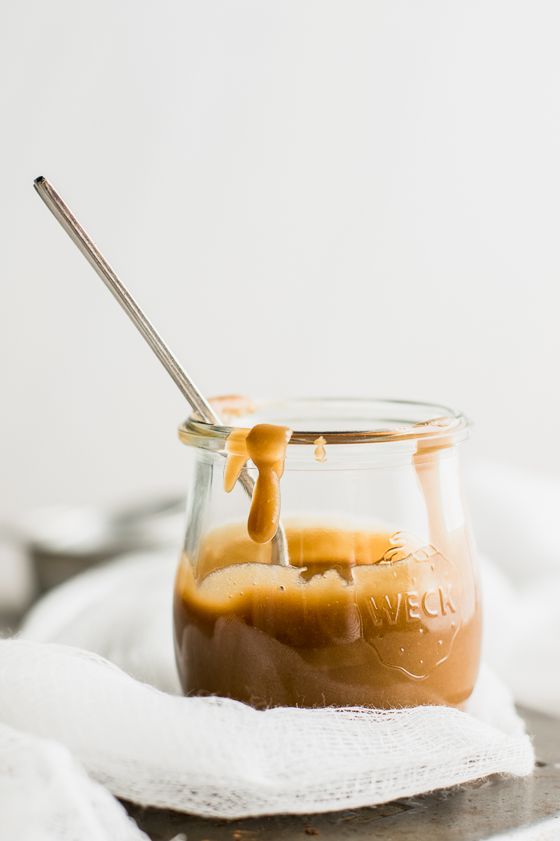 caramel sauce in a jar with a spoon