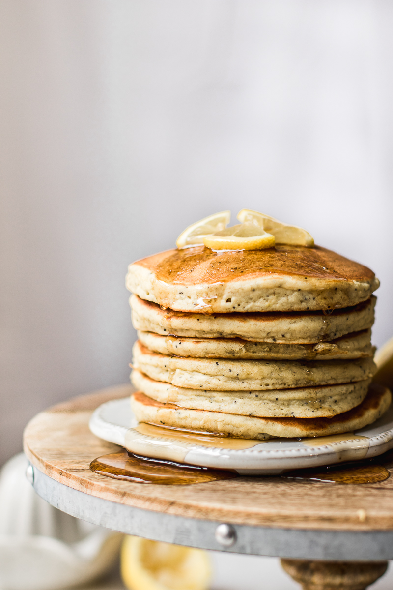Lemon Poppy Seed Pancakes drizzled with maple syrup.