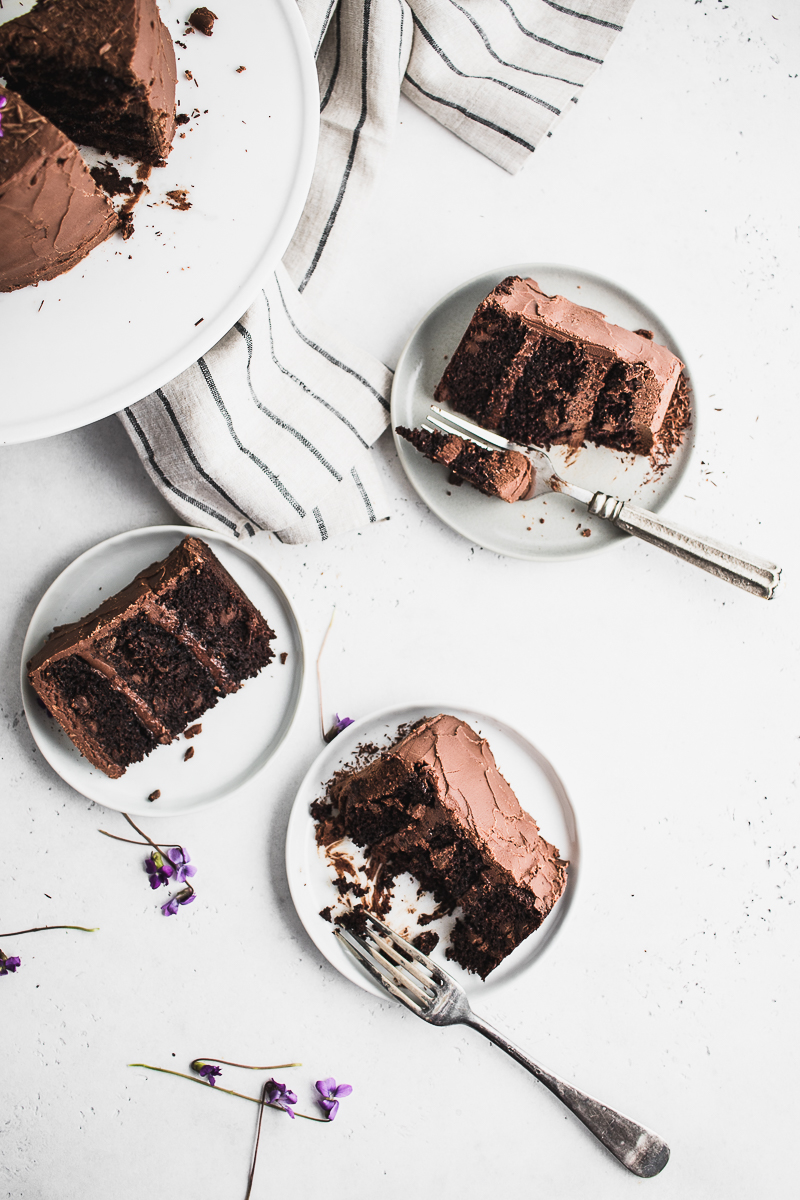 overhead shot of three pieces of chocolate cake and forks
