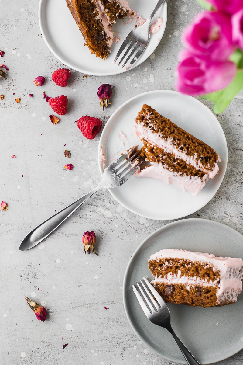 carrot cake slices with forks on plates and raspberries