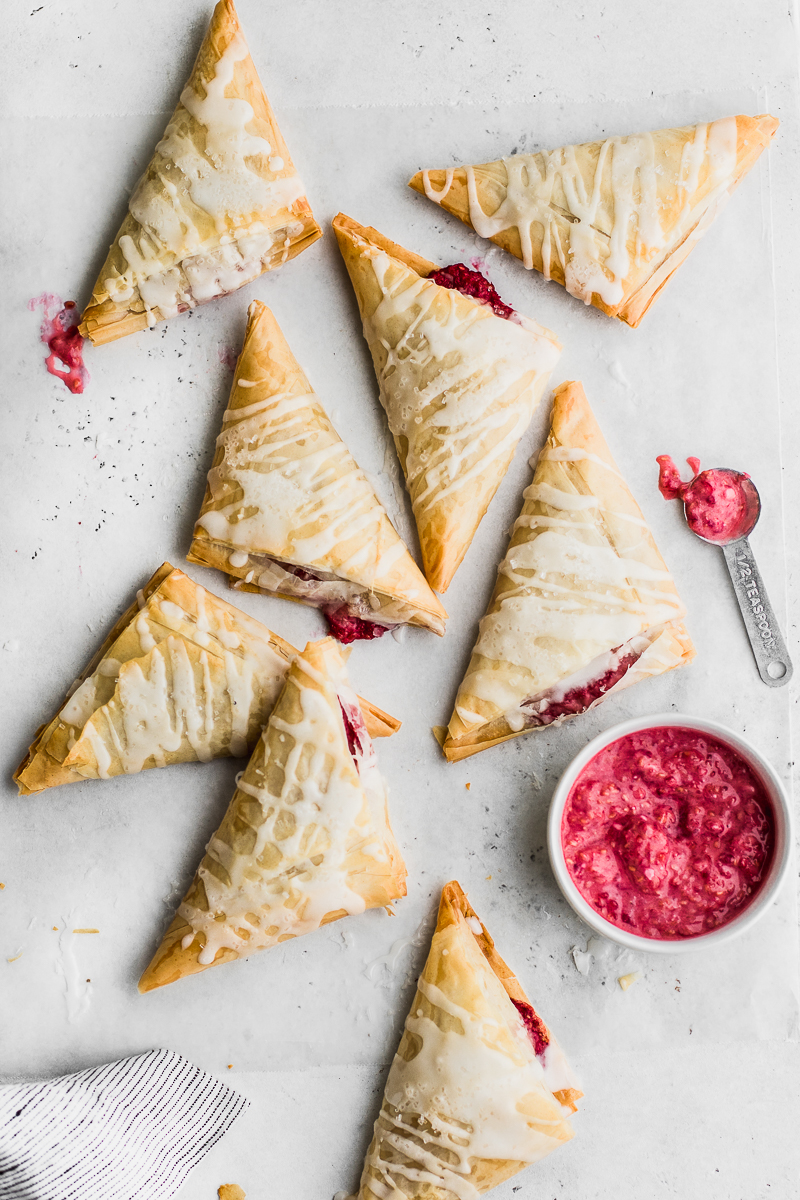 raspberry turnovers with a cup of raspberry sauce