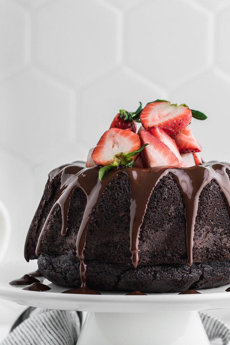 chocolate bundt cake with chocolate drizzle and strawberries