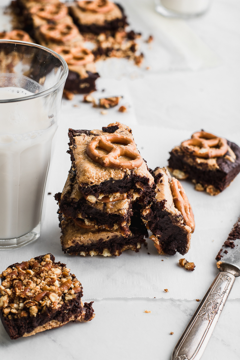 brownies stacked with peanut peanut butter and pretzels with a cup of milk