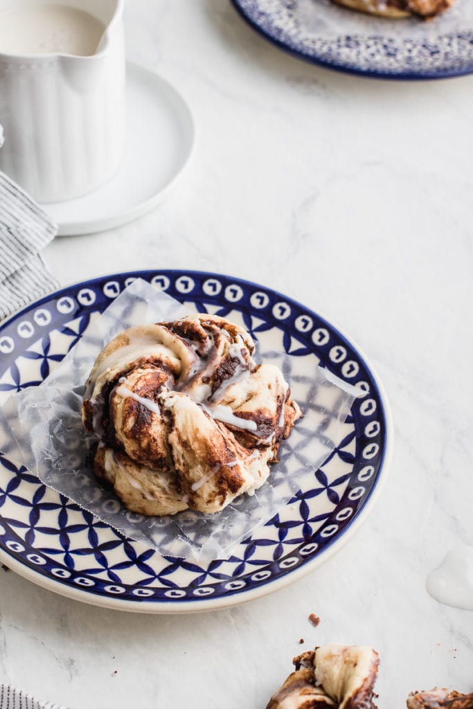 cinnamon buns on white backdrop and on blue plates