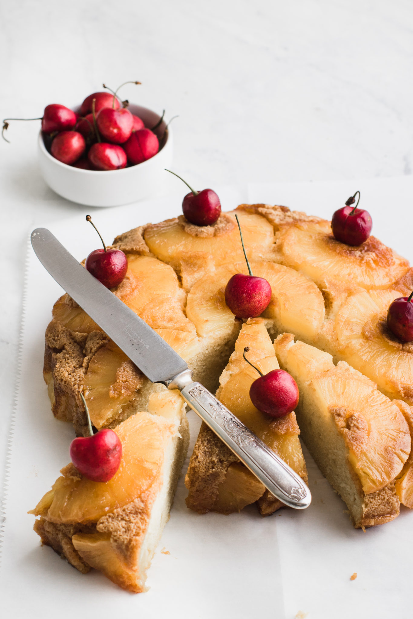 pineapple cake with cherries and knife on top