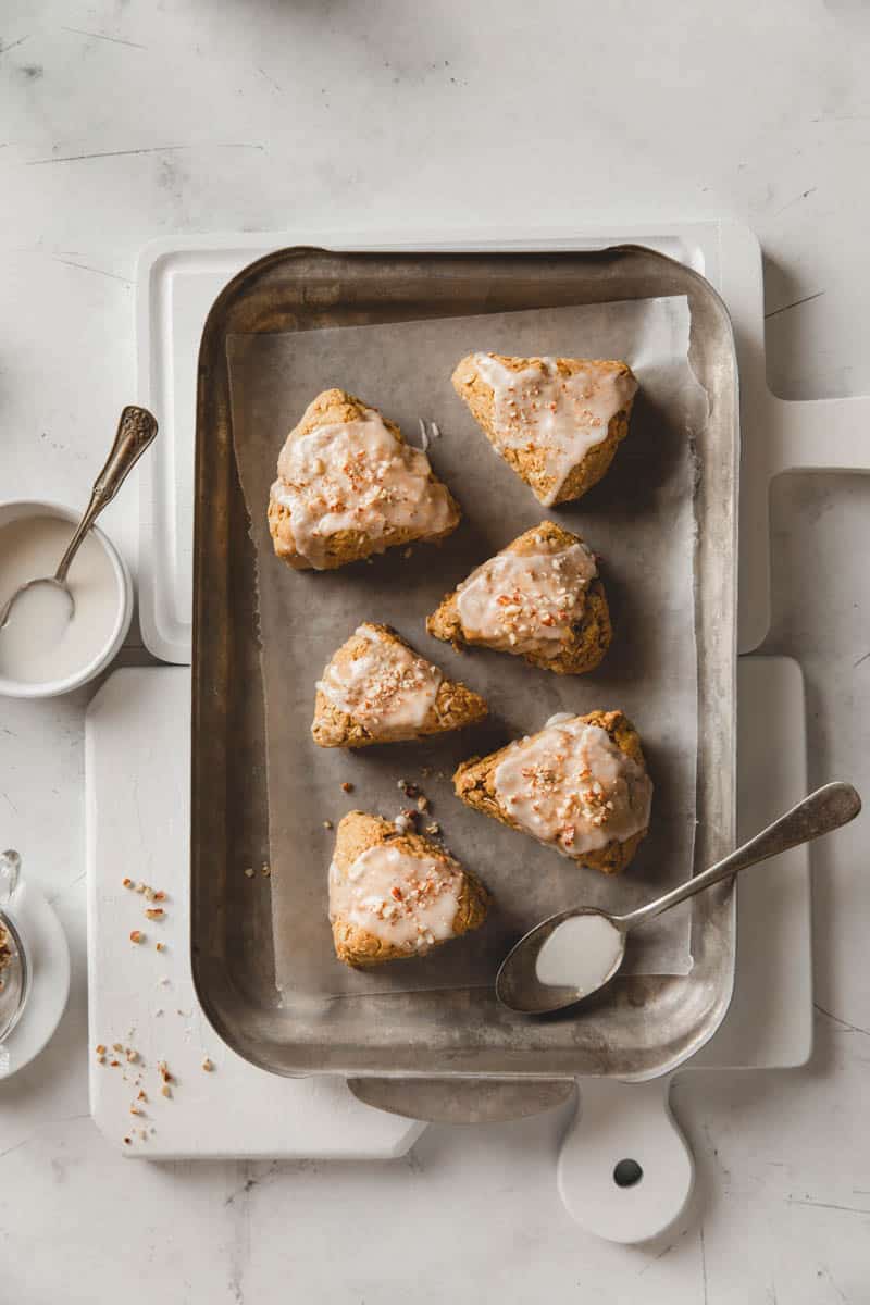 Moist gluten free pumpkin scones are made vegan and topped with frosting.