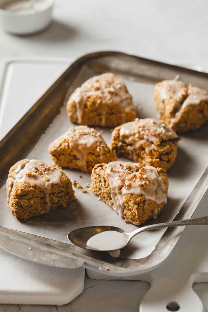 Moist gluten free pumpkin scones are made vegan and topped with frosting.