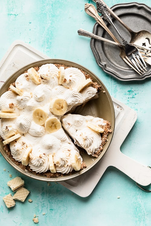 Dairy free banana cream pie in a pan with one slice missing.