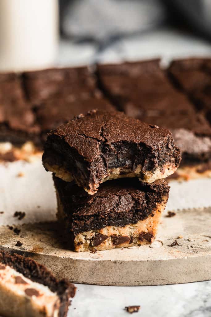 vegan slutty brownies stacked on top of each other with a bite taken out.