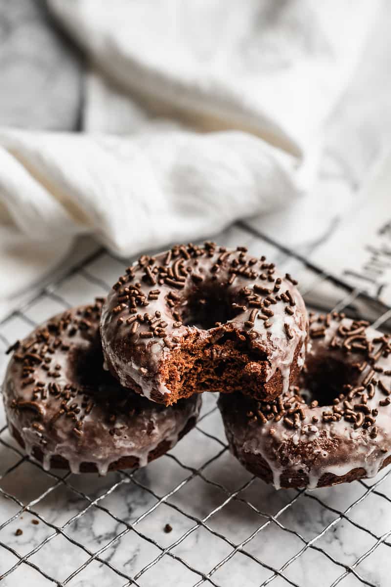 small batch chocolate donuts with sprinkles on white crinkled paper