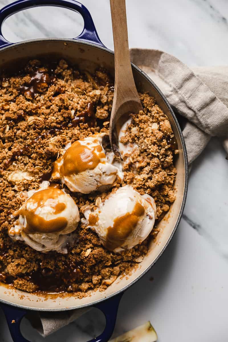 Easy vegan pear crisp with oats made gluten free and dairy free.  Topped with caramel sauce and ice cream.