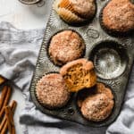 healthy pumpkin muffins in a baking pan with a giant bite taken out of the center gluten free muffin