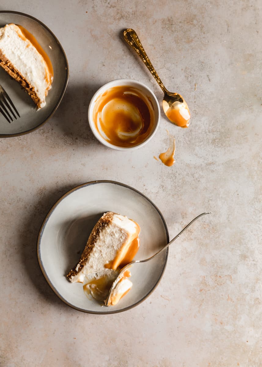 Vegan caramel cheesecake on a cake stand with caramel dripping