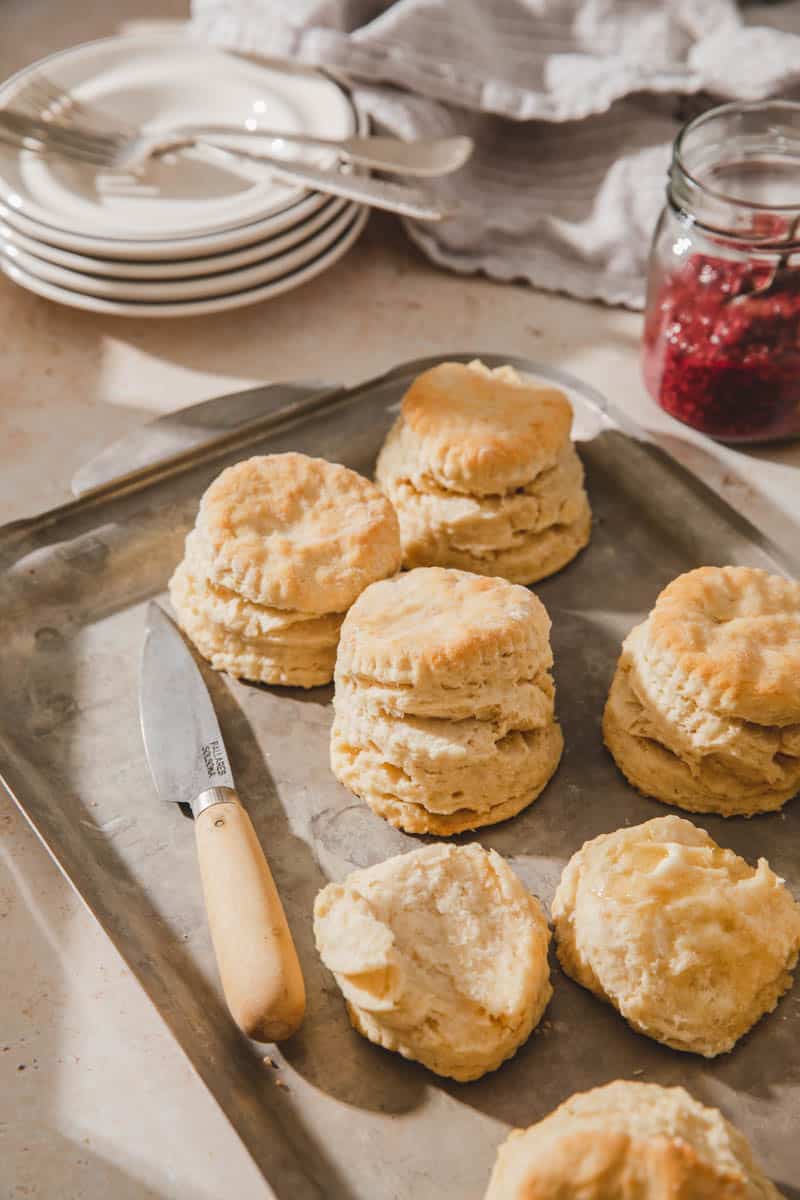 The best flaky vegan biscuits on a baking sheet with vegan butter.