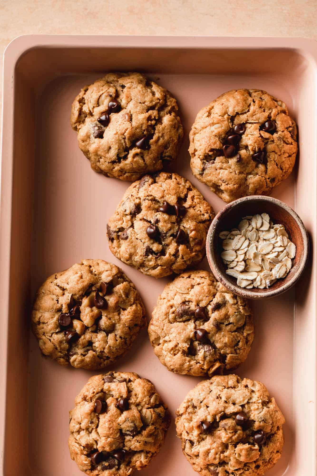 A pan of vegan peanut butter oatmeal cookies bursting with chocolate chips and walnuts.
