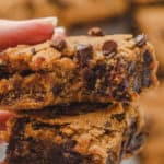 pumpkin bars with chocolate chips stacked on top of each other. Pumpkin blondies with a bite taken out.