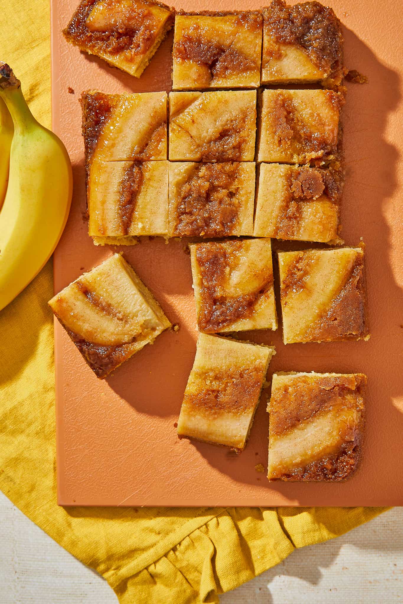 A gooey caramelized banana upside down cake with slices cut out.